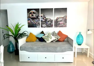 a room with a bed with colorful pillows on it at GroveO1 10 min from the beach in Miami