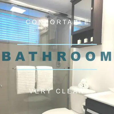 a bathroom with a toilet and a glass window at GroveO1 10 min from the beach in Miami