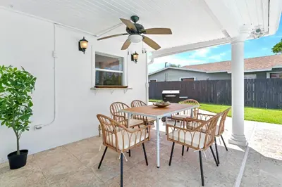 a patio with a table and chairs and a ceiling fan at Casa Cabos - Fun in Miami - Pool BBQ - Fit 10 in Tamiami