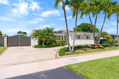 a house with palm trees and a driveway at Casa Cabos - Fun in Miami - Pool BBQ - Fit 10 in Tamiami