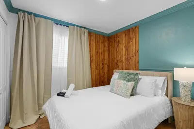 a bedroom with a bed with white sheets and a window at Casa Cabos - Fun in Miami - Pool BBQ - Fit 10 in Tamiami