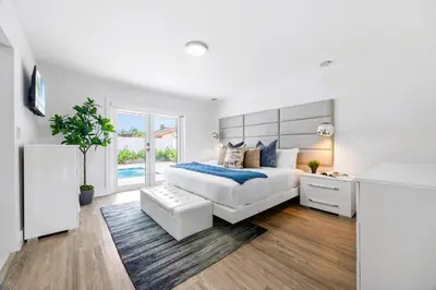 a white bedroom with a large bed and a window at Gables Paradise - Htd Pool,5 Bdrooms ,Mini Golf, Playground, Baby Items, BBQ in Tamiami