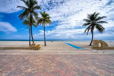 a sandy beach with palm trees and the ocean at Casa Roselle On The Beach Full 22 in Hollywood