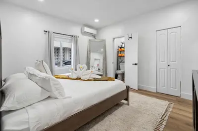 a white bedroom with a large bed with a mirror at Casa Roselle On The Beach Full 22 in Hollywood