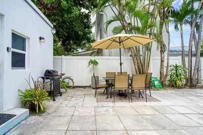 a patio with a table and chairs and an umbrella at Casa Roselle On The Beach Full 22 in Hollywood