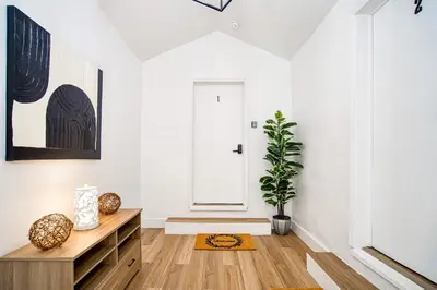 a living room with a wooden dresser and a door at Casa Roselle On The Beach Full 22 in Hollywood