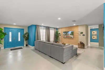 a living room with a couch and a blue door at Casa Maldivas - Blue Oasis - Heated Pool in Tamiami