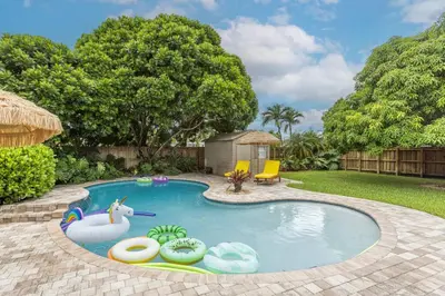 a swimming pool with an inflatable animal in a yard at Casa Mexican home - Big Pool - Hot Tub - FITS 12 in Miami