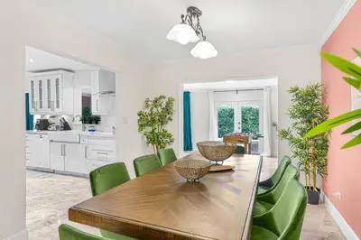 a kitchen and dining room with a wooden table and green chairs at Casa Praga - Big pool & BBQ - Miami Fun in Tamiami