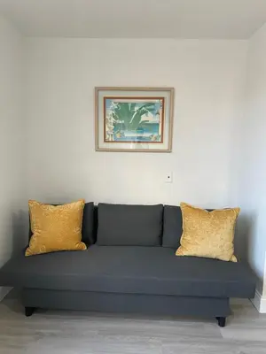 a blue couch with yellow pillows in a room at TROPICAL HAVEN POOL & 2BLOCKS TO BEACh in Miami Beach