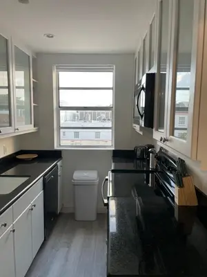 a kitchen with black counter tops and a window at TROPICAL HAVEN POOL & 2BLOCKS TO BEACh in Miami Beach