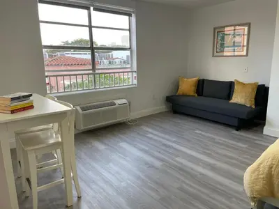 a living room with a couch and a window at TROPICAL HAVEN POOL & 2BLOCKS TO BEACh in Miami Beach
