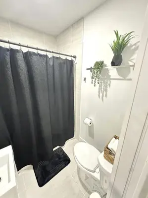 a bathroom with a black shower curtain and a toilet at Stay Where Miami Comes Alive in Miami