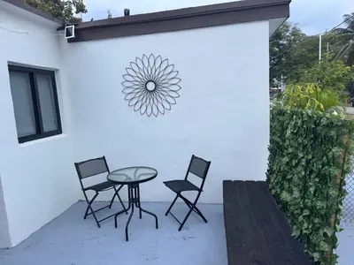 a patio with a table and chairs and a wall with a sun sign at Artful Luxury in Miami Most Iconic Spot in Miami