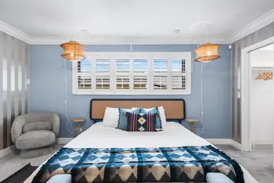 a bedroom with a bed and a chair and a window at Centrally Located 4BD Oasis with Pool & Movie Patio in Hollywood