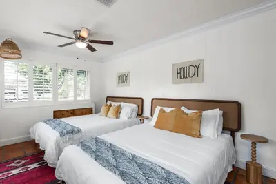 two beds in a bedroom with white walls and a ceiling fan at Centrally Located 4BD Oasis with Pool & Movie Patio in Hollywood