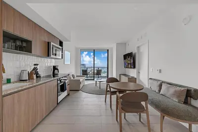 a kitchen and living room with a table and chairs at Trendy Escape with Pool Gym 24th-Floor Views in Miami