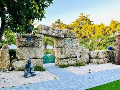 a statue of a woman sitting next to a stone wall at Lake Of Dreams Miami House in Miami