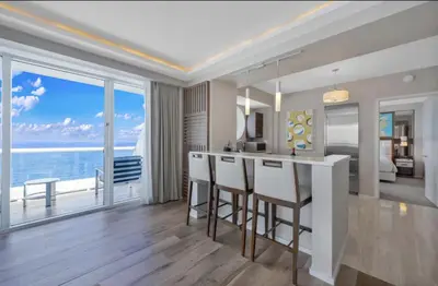a kitchen and living room with a view of the ocean at Beachfront Condo Fort Lauderdale in Fort Lauderdale
