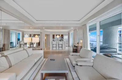 a living room with white furniture and a large window at Beachfront Condo Fort Lauderdale in Fort Lauderdale