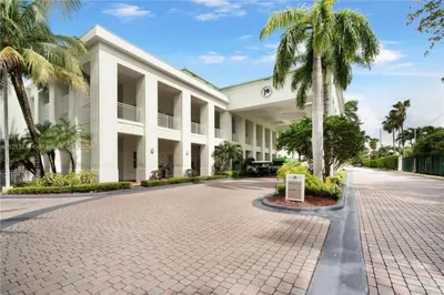 a large white building with palm trees in front of it at Doral Pool 1407 by WaveProperties in Miami
