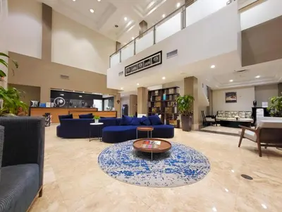 a large lobby with blue couches and a coffee table at Doral Pool 1407 by WaveProperties in Miami