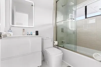 a white bathroom with a toilet and a glass shower at April Sale! 4BR - Private Yard, Grill, Soaking Tub, Near Coral Gables & MIA Airport in Tamiami