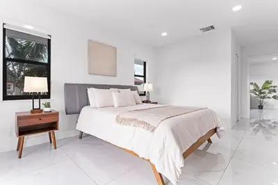 a white bedroom with a large bed and a table at April Sale! 4 BR - Private Pool, Grill, Soaking Tub, Near Coral Gables & MIA Airport in Miami