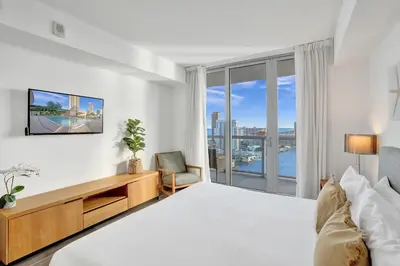 a bedroom with a large bed and a large window at Beachwalk Resort in Hallandale Beach