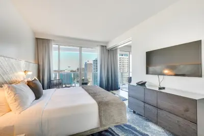 a bedroom with a large bed and a large television at Walk to Bars and Eats! Luxe Ft Lauderdale Condo in Fort Lauderdale