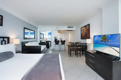 a bedroom with a large bed and a living room at Castle 732 Ocean View with pool, tennis, beach access, FREE parking in Miami Beach