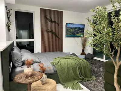 a living room with a bed and a green blanket at MONROE APART HOTEl in Hollywood