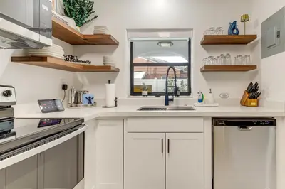 a white kitchen with a sink and a window at The Peacock Bungalow Near Fort Lauderdale Beach! in Fort Lauderdale