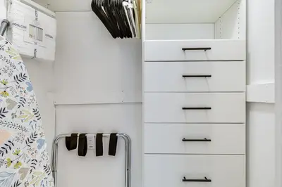 a closet with white drawers and a shelf at The Peacock Bungalow Near Fort Lauderdale Beach! in Fort Lauderdale