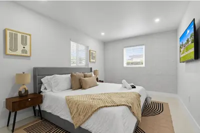 a bedroom with a large bed and a television at Miami Japandi Style Pool - BBQ in Miami