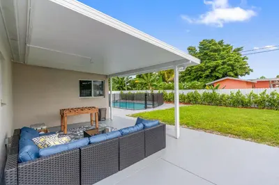 a covered patio with a blue couch under a pavilion at Miami Japandi Style Pool - BBQ in Miami
