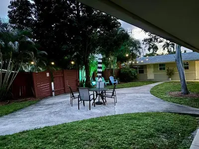 a patio with a table and chairs in a yard at New comfortable and youthful sport in Fort Lauderdale
