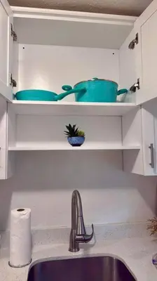 a kitchen with a sink and some bowls on shelves at New comfortable and youthful sport in Fort Lauderdale