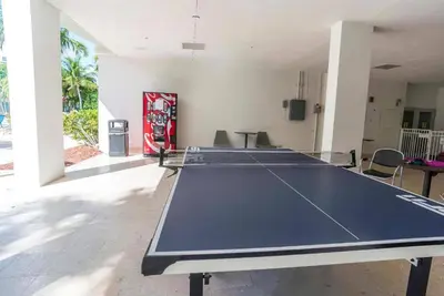 a ping pong table in the middle of a room at Spacious 3 BR plus 1 office and 2 BA with Free parking Just in front beach in Sunny Isles Beach