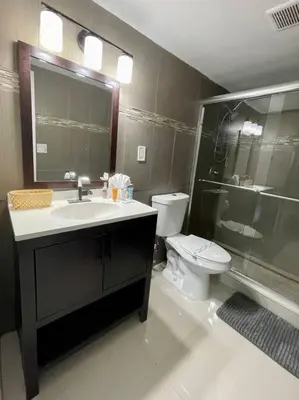 a bathroom with a sink and a toilet and a shower at Spacious 3 BR plus 1 office and 2 BA with Free parking Just in front beach in Sunny Isles Beach