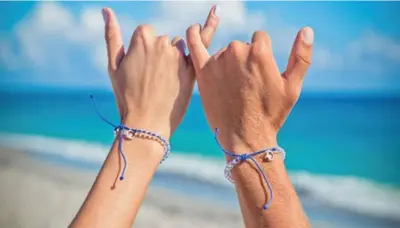 a woman holding her hands up in the air on the beach at Cozy Apartment on South Beach in Miami Beach