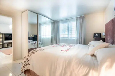 a bedroom with a large white bed with a large mirror at Cozy Apartment on South Beach in Miami Beach