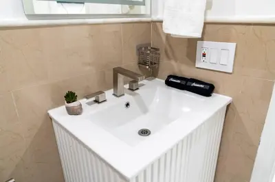 a white sink in a bathroom with a mirror at Luxury Retreat 3B ,2Ba POOL , Coral Gables Center in Miami