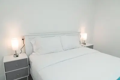 a bedroom with a white bed with two night stands at Luxury Retreat 3B ,2Ba POOL , Coral Gables Center in Miami