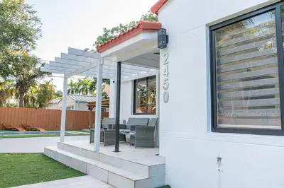 a white house with a patio and a pool at Luxury Retreat 3B ,2Ba POOL , Coral Gables Center in Miami