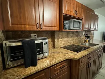 a kitchen counter with a microwave and a stove at Beach Escape private studio in Sunny Isles Beach
