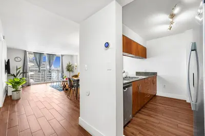 an open kitchen with white walls and wooden floors at Exclusive 1BR Apartment on 35th floor in Miami