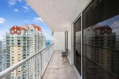 a balcony with a chair and a view of buildings at Exclusive 1BR Apartment on 35th floor in Miami