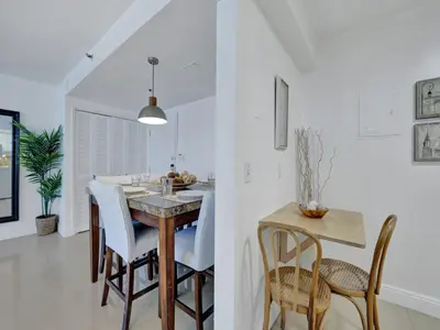 a kitchen and dining room with a table and chairs at Charming Ocean View Condo with Beach Service 1516 in Miami Beach