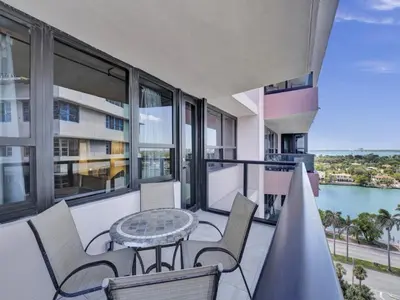 a balcony with a table and chairs and a view of the water at Charming Ocean View Condo with Beach Service 1516 in Miami Beach